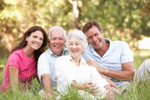 Elder happy family smiling and sitting on a lawn together