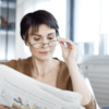 Mid woman Reading newspaper with eyeglasses