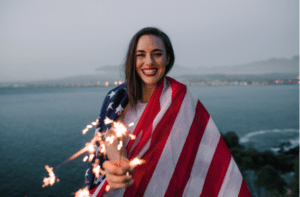 woman holding American flag celebrating holding sparkles