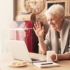 Elderly woman making video call on laptop in kitchen
