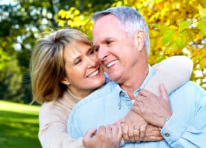 Older couple hugs, happy to have restored vision after treating eye ailments.